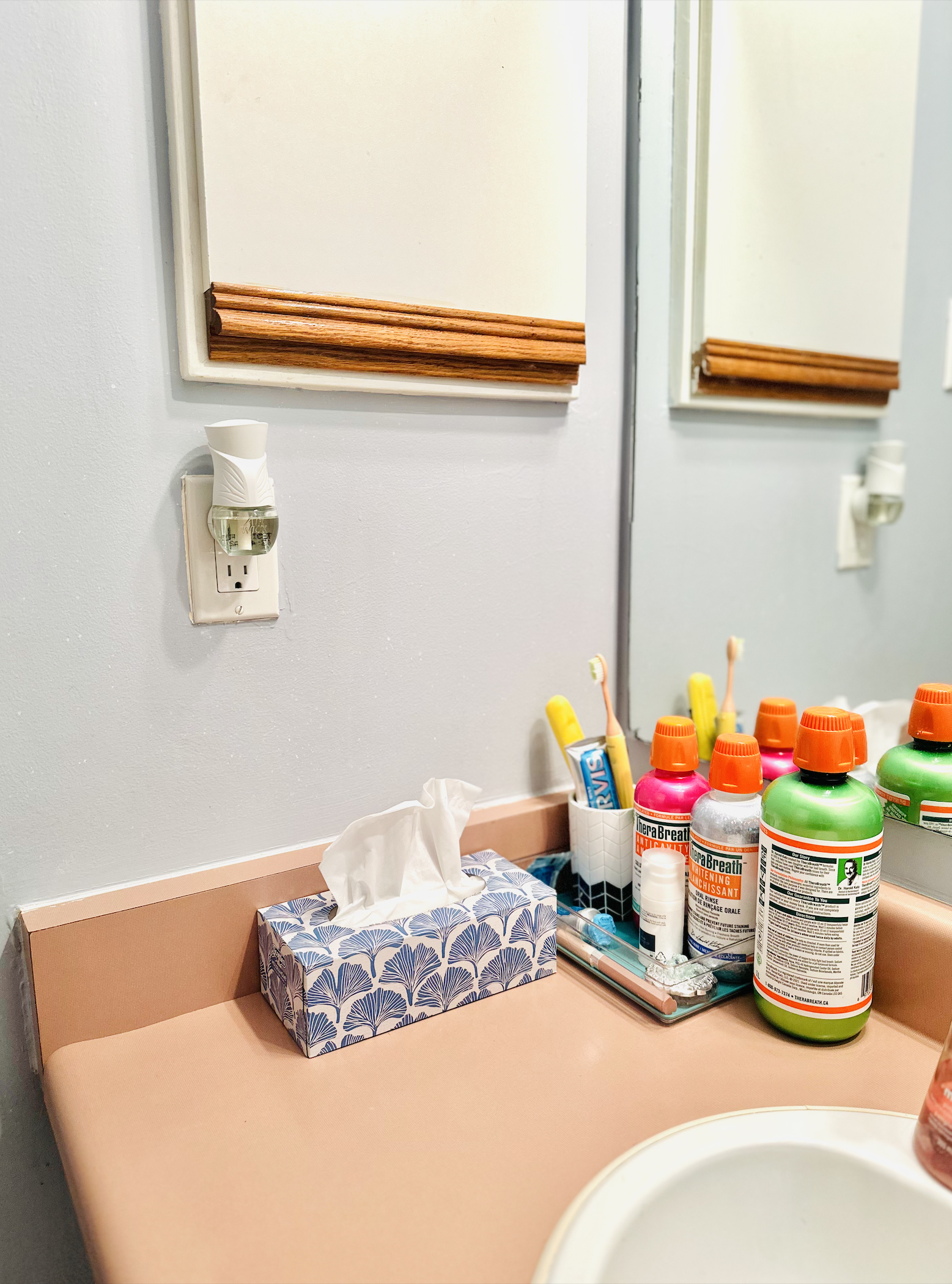 An electric air freshener plugged into a bathroom wall outlet